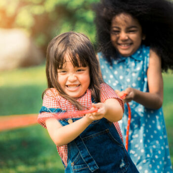 2 petites filles tirent sur une corde au jeu de force