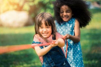 2 petites filles tirent sur une corde au jeu de force